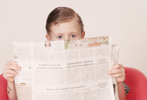 child reading news